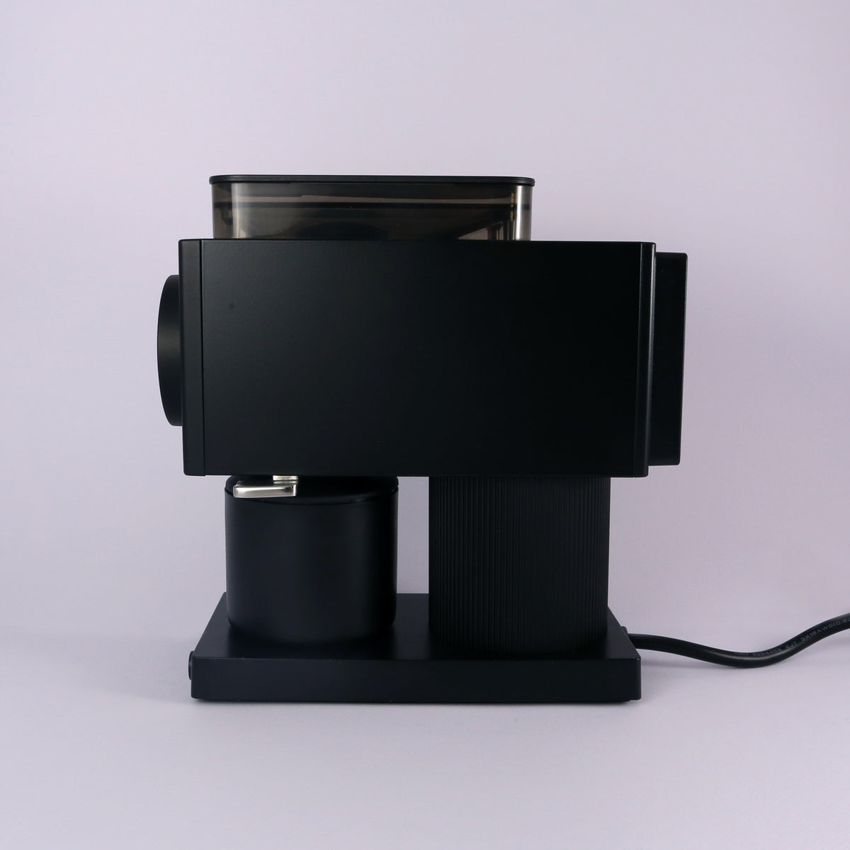 The Tandem Fellow Ode Brew Grinder Gen 2, a sleek black flat burr grinder, rests on a light gray surface with its power cord visible, set against a plain light background.