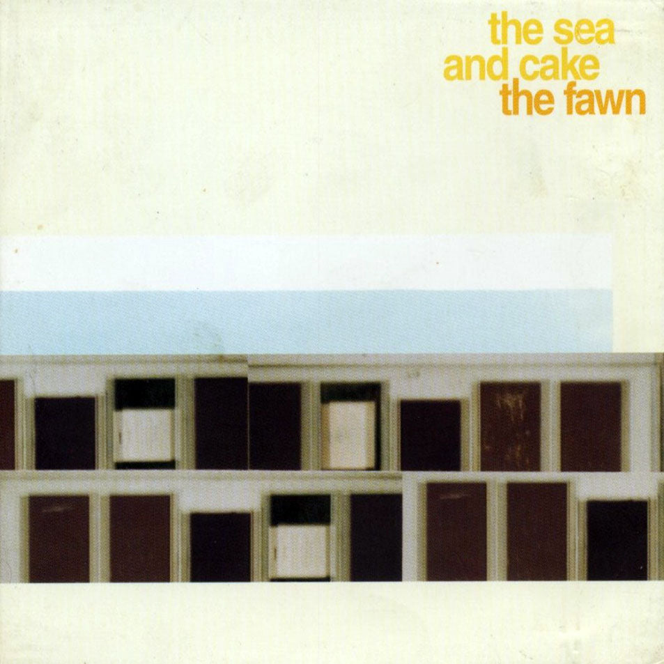 The Sea and Cake - The Fawn, from Tandem Coffee Roasters, features a minimalist building facade with rectangular windows in muted colors; album and band names appear in yellow text at the top right.